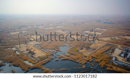 Aerial view of wetland landscape with oil pump, oil well, pipeline and petroleum factory in Panjin, Liaoning, China