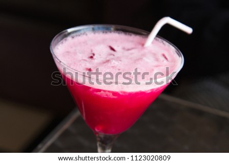 A close up shot of a Pink Martini drink with a straw. This image can be used to represent cocktail drinks. 