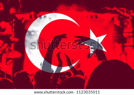 Crowd of people with raised arms over blending Turkey flag