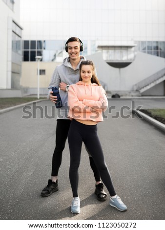 A young man and a girl are resting after a hard workout in the city.Sport in an urban environment. The photo illustrates a healthy lifestyle and sports.