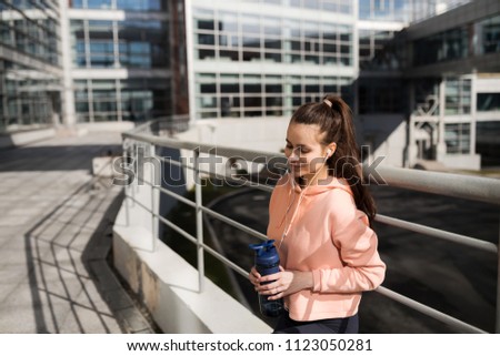 Girl student engaged in sports in the city. Sport in an urban environment. Girl resting after a hard workout in the city. The photo illustrates a healthy lifestyle and sports.