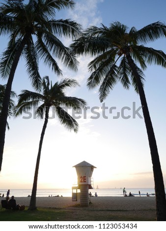 Waikiki beach lifeguard tower golden hour people enjoying sunset Hawaii island Oahu Honolulu tropical palm trees