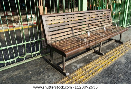   wooden bench beside blind path                              