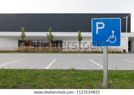 Disabled traffic sign at an empty car park represent handicap parking space without car or people