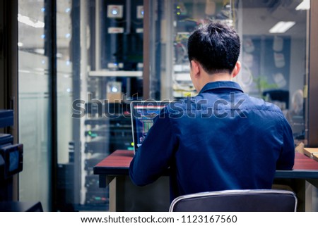 Technicians using laptop while analyzing server in server room