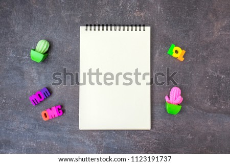 Hipster youth cool mockup blank notebook with toy cactuses and words OMG MOM LOL and figures of hands, gestures on dark background.