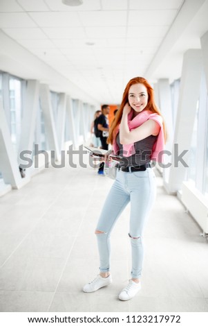 Young red-haired student at the University. A group of young students from different countries. The photo illustrates education, College, school, or University.