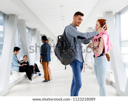 A young guy puts the girl headphones. The photo illustrates education, College, school, or University.