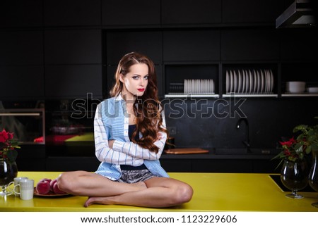Beautiful young woman in a kitchen room, casual clothes, lifestyle portrait