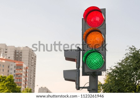 Street car traffic light with burning green, orange and red lights at the same time