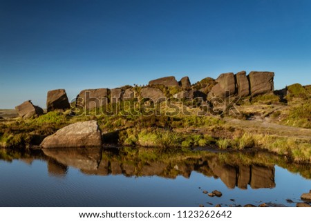 Reflections on Doxey pool with a beautiful blue sky. On the Roaches in the Peak District National park.