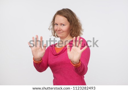 European woman saying thanks but no, denying proposal, making stop gesture with her hands, looking at camera. It is enough concept