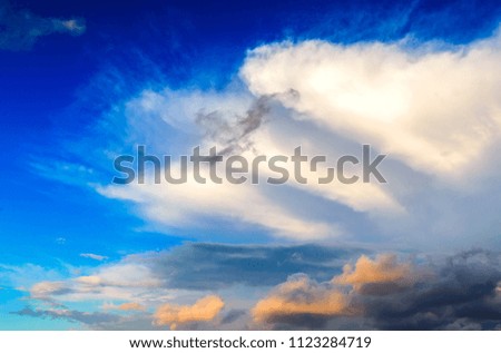 Incredible lenticular clouds in sky during sunset. Fiery orange sunset sky with colorful combinations of colors and shades of sunlight spectrum