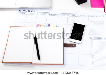 Book,laptop,pen,steel pen's box and scissors are on the white table in room or office,knowledge for search information and prepare short note shopping on line.