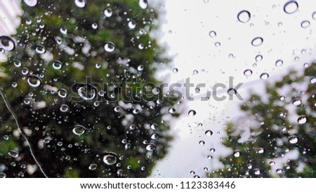 View through a window on a rainy ,Rain drops on window in rainy season abstract background.