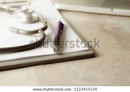 Focus Stethoscope Doctor table on bord with pen.