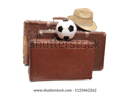 Old suitcase and soccer ball on white background