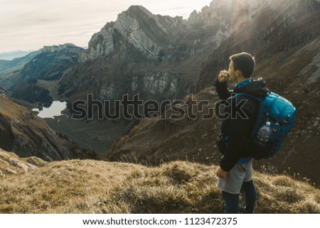 The young tourist stands by Lake Seealpsee overlooking the mountains, Seealpsee Switzerland Appenzell
