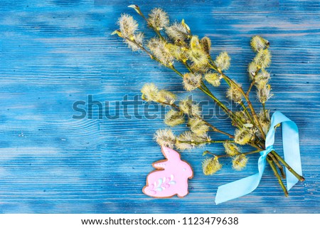 Willow branch and Easter cookie on bright background. Studio Photo

