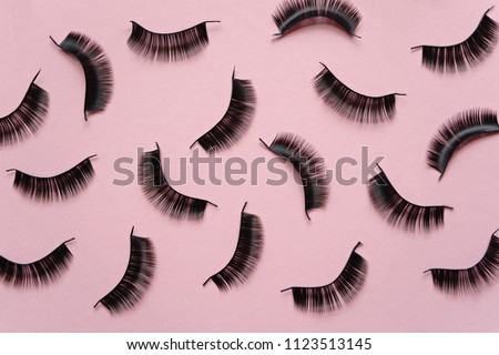 Black false lashes strips on pink background  Royalty-Free Stock Photo #1123513145