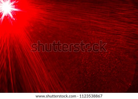Camera lens flare by red laser light create effects depending on iris shapes, number of lens surface of objective and interference effect and moire on digital sensor on dark black background