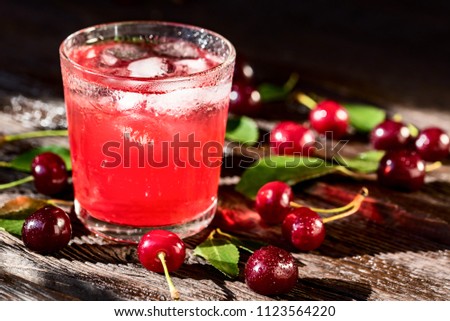 Fresh cherries and ice cherry fruit drink on wood