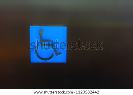 The symbol of the disabled in the elevator.