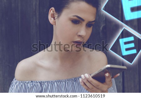 Serious woman holding her phone, symbol letter E on side. concept