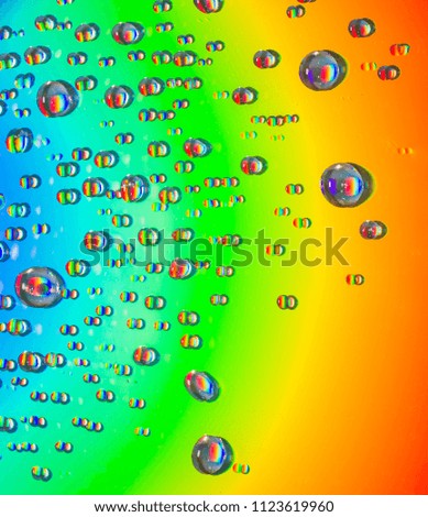 Closeup of water drops on field of beautiful rainbow colors.