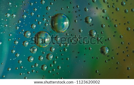 Beautiful closeup of water droplets floating on blue-green background
