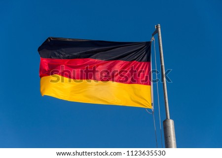 German flag waving against blue sky in Boulogne sur Mer, France.