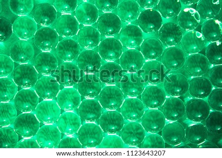 Gel green balls on green cloth. Hydrogel. Glass bead. Texture or background. Closeup macro