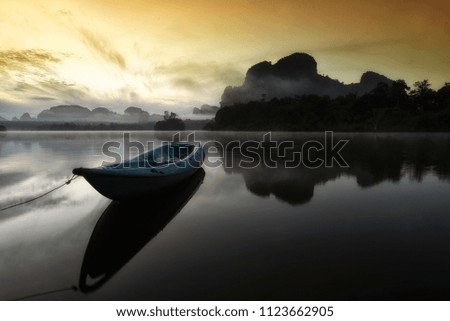 Small boat in beautiful and foggy lake