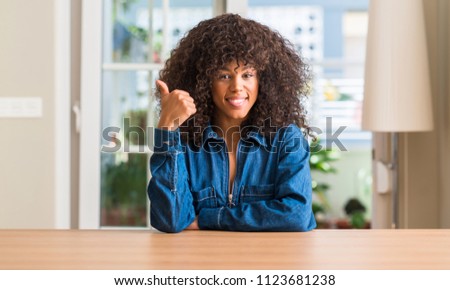 African american woman at home happy with big smile doing ok sign, thumb up with fingers, excellent sign