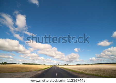 Clouds over rural road. Royalty-Free Stock Photo #112369448