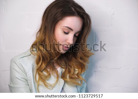 Portrait of a girl with flowing curls with closed eyes on a white background. Horizontal photo