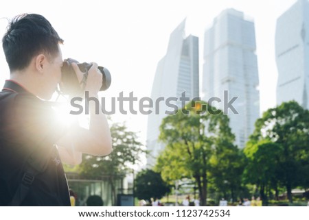 A male photographer takes a backpack and camera to photograph the city.