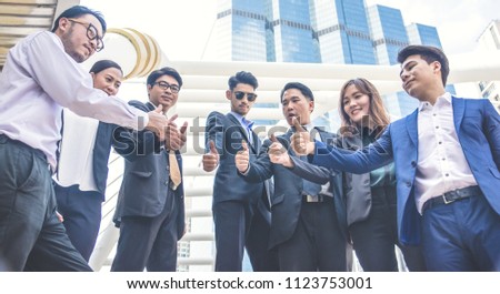 Successful business people with thumbs up and smiling, business team