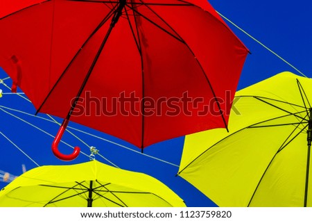 Colourful umbrellas urban street decoration. Hanging colorful umbrellas over blue sky, tourist attraction, sunny day