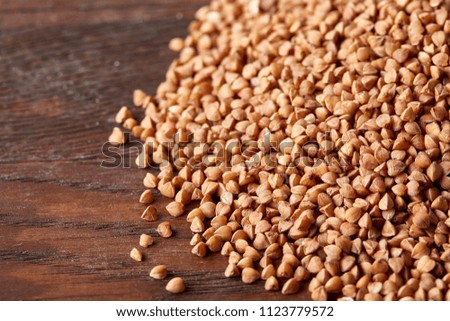 Buckwheat groats on wooden background, top view, close-up, selective focus, shallow depth of field