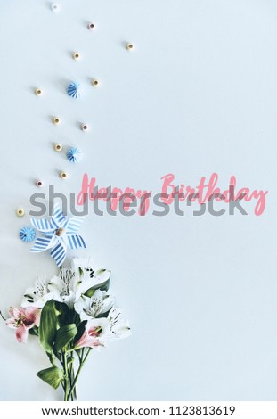 Happy birthday! High angle shot of flowers lying against white background