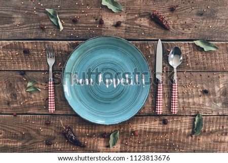 Dinner time. High angle shot of empty plate, fork, spoon, knife lying on rustic table