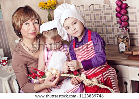 Young grandmother with her grandchildren on the kitchen making dinner together. Ideal family picture. 
