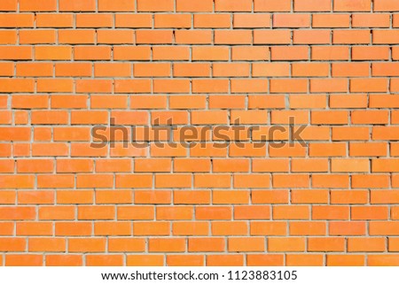 Red brick wall background on sunny summer day.