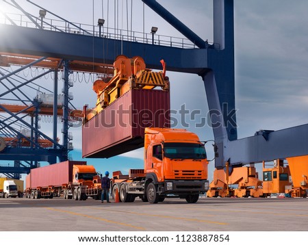 The container vessel during loading at an industrial port by port crane. Royalty-Free Stock Photo #1123887854