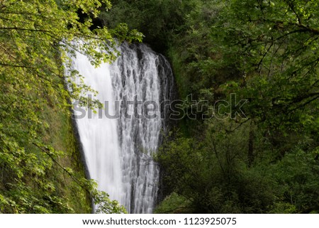Bridal veil waterfall, top part. Long exposure with silky water and green shrubs and trees in the surrounding.