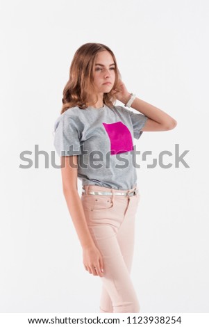 Young blond girl in pink pants posing on white background