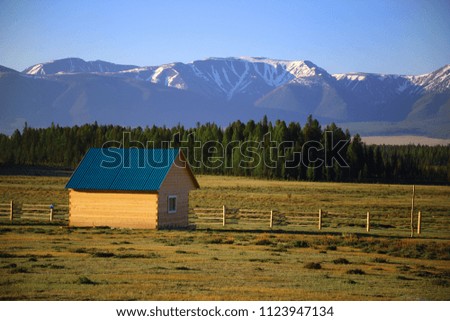 Small wooden house for tourists on a background of the mountains covered by a snow