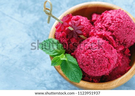 Homemade beetroot ice cream in a bowl decorated with beetroot on a wooden skewer.