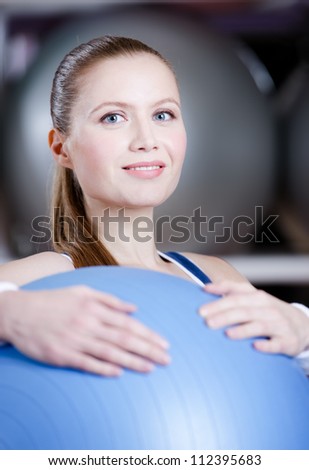 Athlete woman with blue gym ball in fitness gym